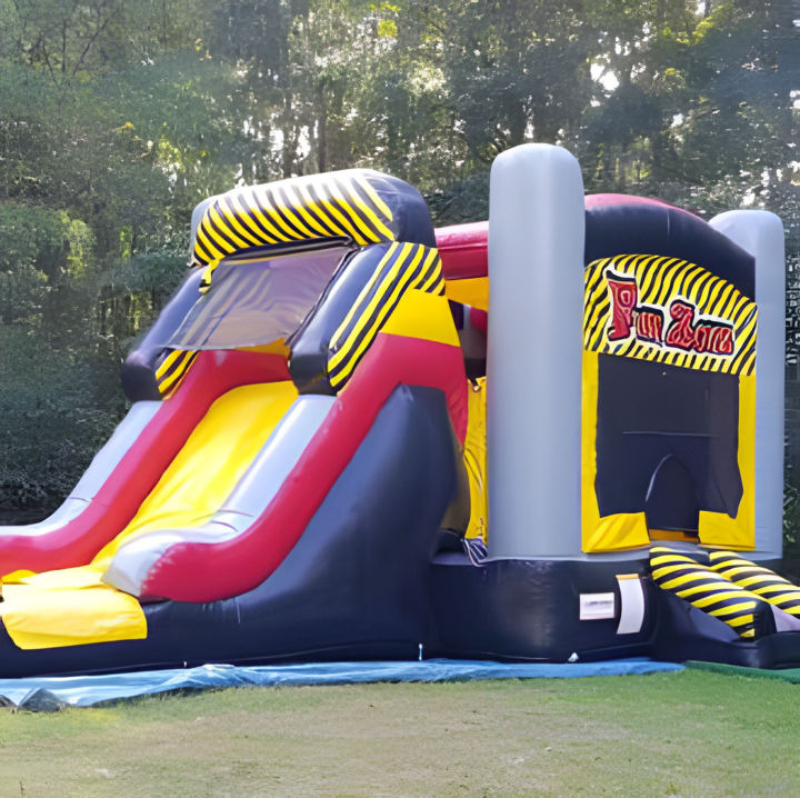 Le Chatoboggan, château gonflable rouge et jaune avec toboggan, sur une pelouse