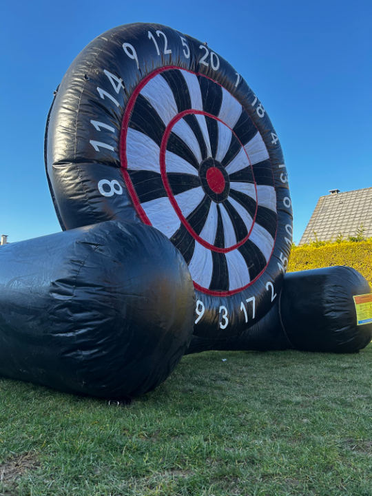 La cible foot, grande cible gonflable noire et blanche sur l'herbe, sous un ciel bleu