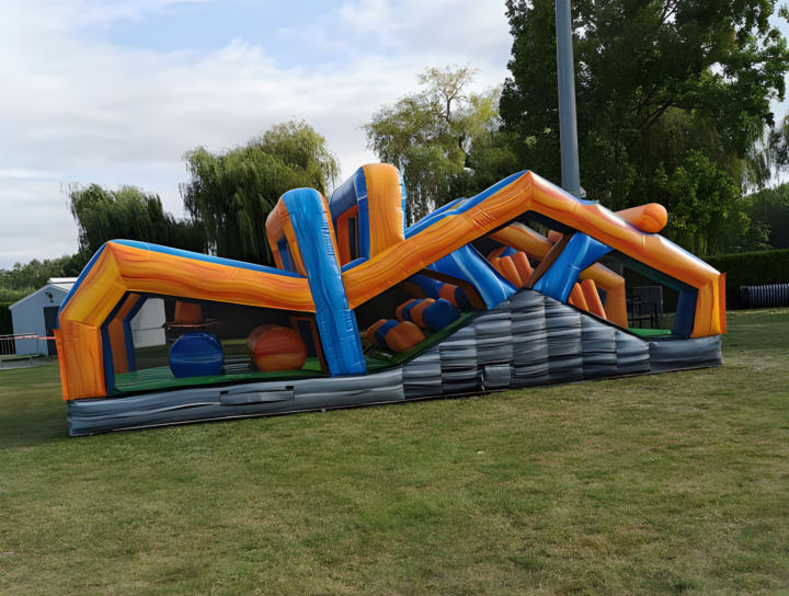 Le parcours Megarun, structure gonflable orange et bleue en zigzag, sur une pelouse