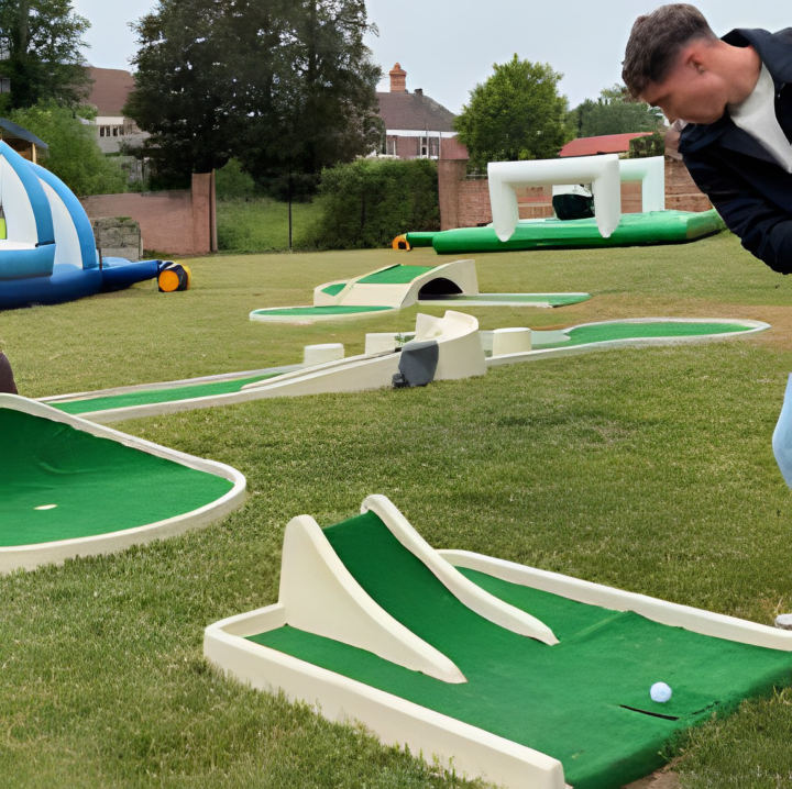 Le minigolf, pistes vertes posées sur une pelouse, un joueur au putt